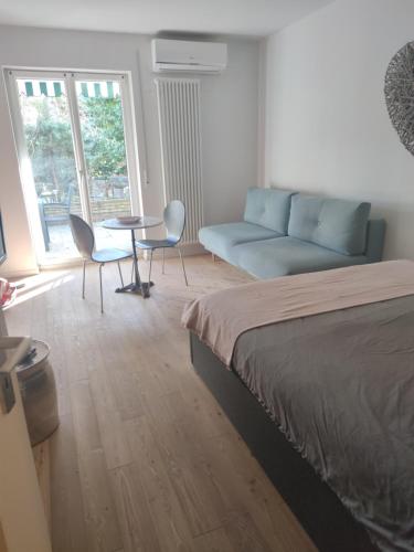 a bedroom with a bed and a couch and a table at Lovely Apartment with pool and garden in Marlengo