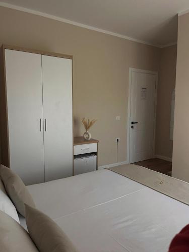 a bedroom with a large white bed and a cabinet at Villa Tabaku in Berat