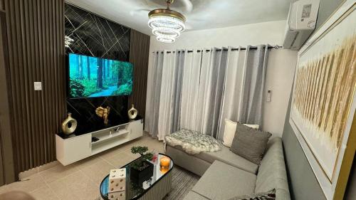 a living room with a couch and a large screen tv at Sweet dreams Tropical paradise in San Isidro