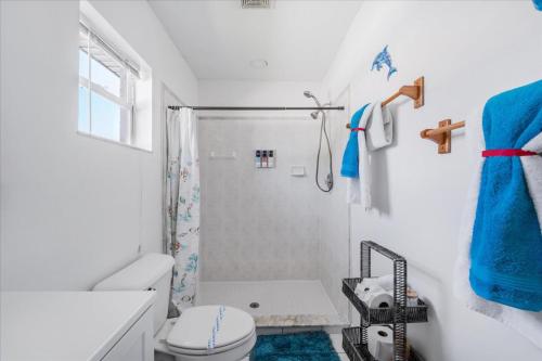 a white bathroom with a toilet and a shower at 5 Star, Twin Home, Heated Pool Located D-town Cape in Cape Coral