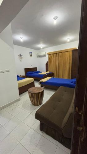 a room with three beds and a couch in it at Sina house in Dahab