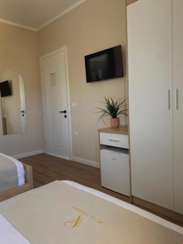 a bedroom with a bed and a tv on the wall at Villa Tabaku in Berat