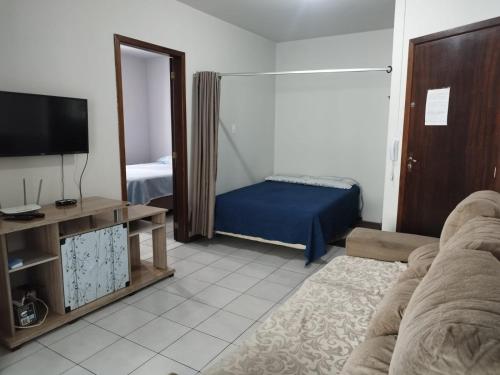 Apartamento de Praia no Centro في ايتابيما: غرفة معيشة مع أريكة وتلفزيون