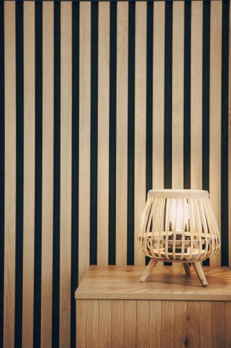 a lamp on a table in front of a striped wall at GAIA Beach House - Exclusive Stay & Free Parking in Conil de la Frontera