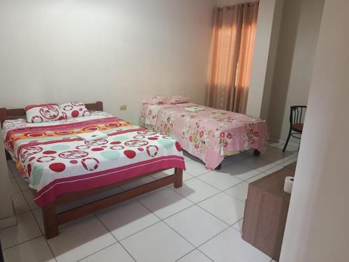 a bedroom with two beds and a table at Hospedaje Cielo Marino in Zorritos