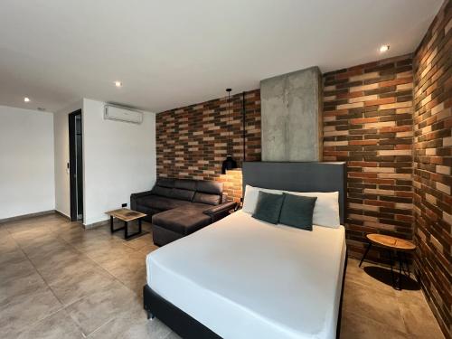a bedroom with a white bed and a brick wall at Apartahotel con Piscina in Medellín