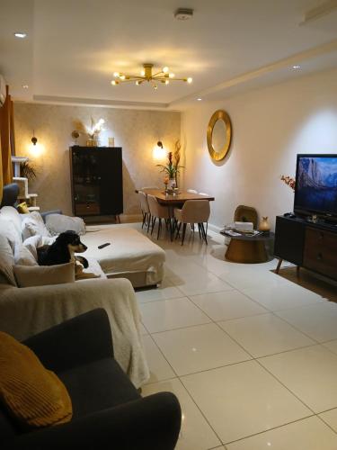 Il comprend un salon doté d'un canapé et d'une télévision. dans l'établissement Maison familiale en Normandie, à Breteuil-sur-Iton