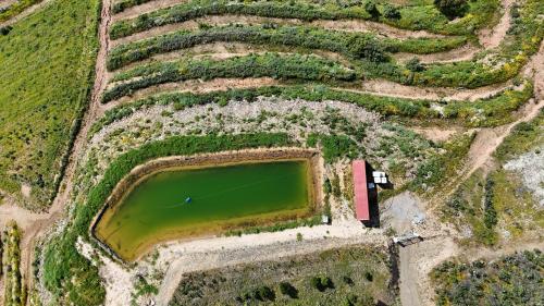 an aerial view of a field with a green pond at Portugals Infinity Eco Suite Resort in Tavira