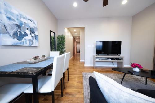a dining room with a table and chairs and a tv at 3 Bedroom Home In Manhattan in New York