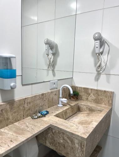 a bathroom with a sink and a mirror at Suítes Ventos e Velas Praia in Pôrto de Pedras