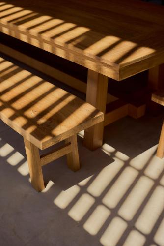 a wooden picnic table and bench in the sunlight at Casa Cambria in Puerto Escondido