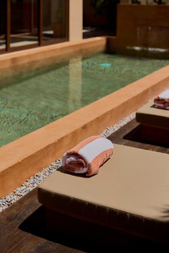 a towel sitting on a table next to a swimming pool at Casa Cambria in Puerto Escondido