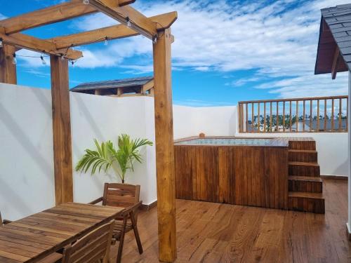 a patio with a wooden table and a wooden pergola at Apartment w private terrace and Jacuzzi in Las Terrenas
