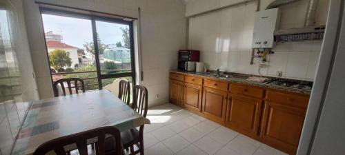 a kitchen with a table and a large window at Golden House in Fátima