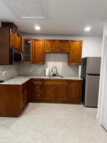 a kitchen with wooden cabinets and a sink and a refrigerator at New Aparment in Tampa in Tampa