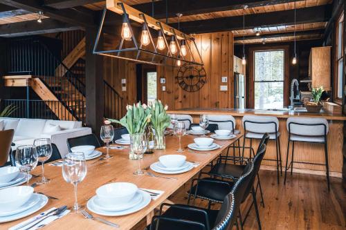 a dining room with a long table and chairs at Family escape w private hot tub in Lac-Superieur