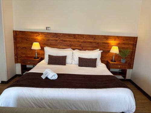 a bedroom with a large bed with two lamps at Cabañas Caleta Hueso in Taltal