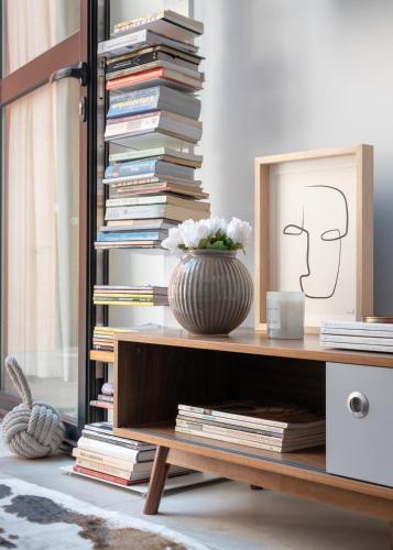 a stack of books on a table with a vase at FILETE, Design house in Peniche's old town in Peniche