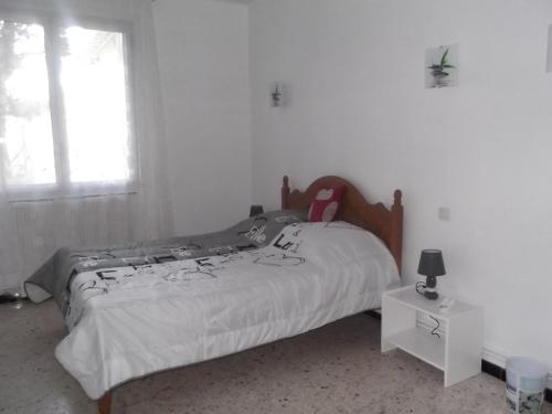 a bedroom with a bed and a window at Chouette coquette in Salses-le-Chateau