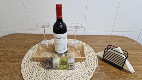 a bottle of wine and two glasses on a table at Apartamento CORAZÓN DE MIÑO in Miño