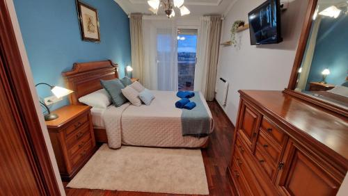 a bedroom with a bed with a blue teddy bear on it at Apartamento CORAZÓN DE MIÑO in Miño