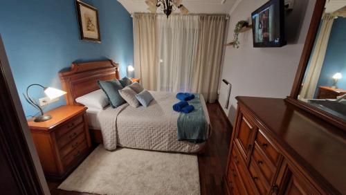 a bedroom with a bed and a dresser and a mirror at Apartamento CORAZÓN DE MIÑO in Miño