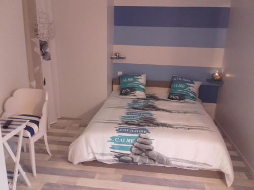 a bedroom with a bed with a striped wall at Jeanne et Compagnie in Loscouët-sur-Meu