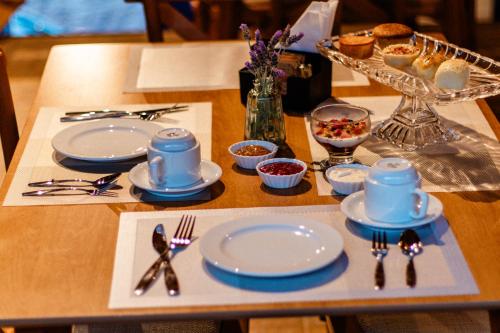 una mesa con platos azules y blancos y cubiertos en Pousada Céu da Chapadha, en Mucugê