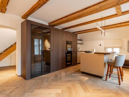 a kitchen with wooden walls and a counter and a table at Villa Filzer in Kirchberg in Tirol