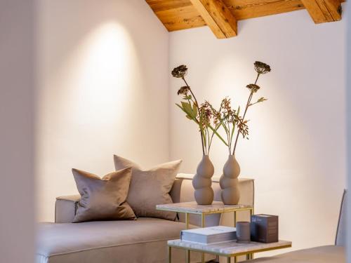 a living room with a couch and two vases on a table at Villa Filzer in Kirchberg in Tirol
