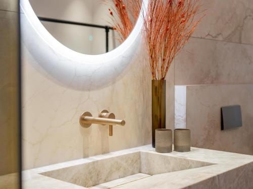 a bathroom sink with a faucet and a mirror at Villa Filzer in Kirchberg in Tirol