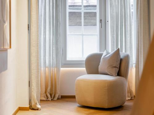 a chair with a pillow sitting in front of a window at Villa Filzer in Kirchberg in Tirol