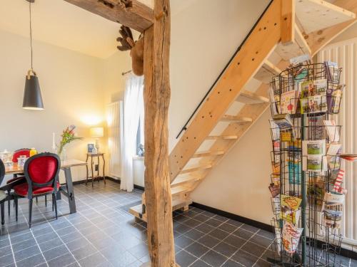 a staircase in a living room with a red chair at Maison Cuberdon in Val-Meer