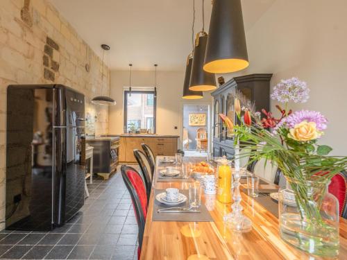 a dining room with a long wooden table with chairs at Maison Cuberdon in Val-Meer