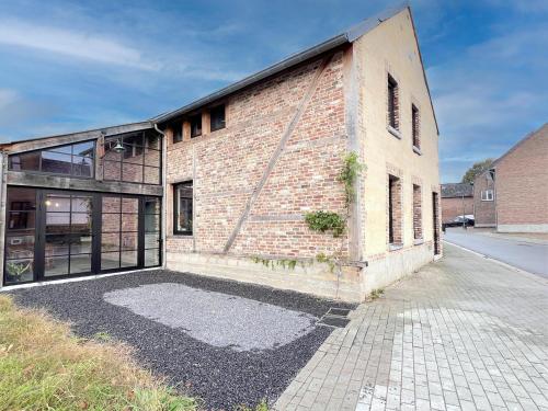an old brick building with a sidewalk in front of it at Maison Cuberdon in Val-Meer