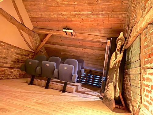 a statue of a man in a room with chairs at Maison Cuberdon in Val-Meer