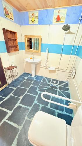 a bathroom with a blue and white floor with a sink at Pensión y Albergue Matias Locanda in Sarria
