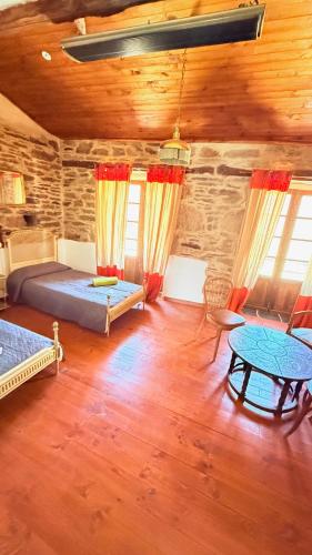 a room with two beds and a table in it at Pensión y Albergue Matias Locanda in Sarria
