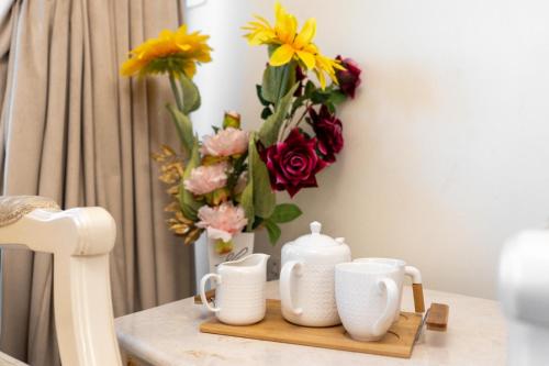 a table with a tray with a vase of flowers at sand and beach haven at Ajman Corniche! in Dubai