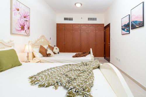 a bedroom with two beds and a wooden headboard at sand and beach haven at Ajman Corniche! in Dubai