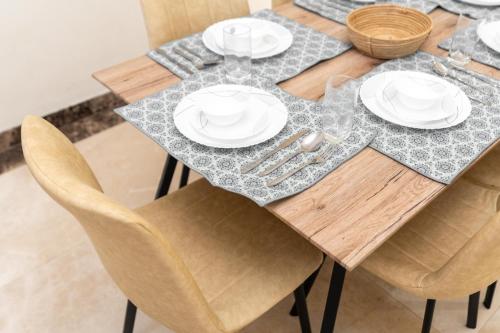 a dining table with white plates and silverware on it at sand and beach haven at Ajman Corniche! in Dubai