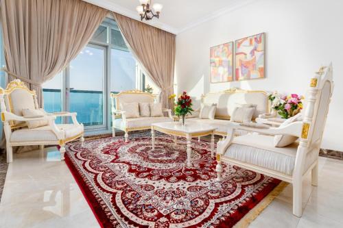 a living room with white furniture and a red rug at sand and beach haven at Ajman Corniche! in Dubai
