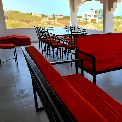 a restaurant with red chairs and a table with a view at Villa Mbine-Diene in Mbodiène