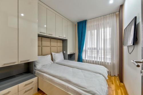 a small bedroom with a bed and a window at Gorski Elegance Apartments Premium in Zlatibor