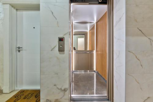 a stainless steel elevator in a bathroom with marble walls at Gorski Elegance Apartments Premium in Zlatibor