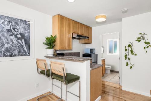 a kitchen with a counter and chairs in a room at Swell House Santa Cruz in Santa Cruz