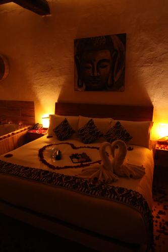 a bedroom with a bed with two swans on it at Mesón De Leyendas Breakfast & Downtown in Valle de Bravo