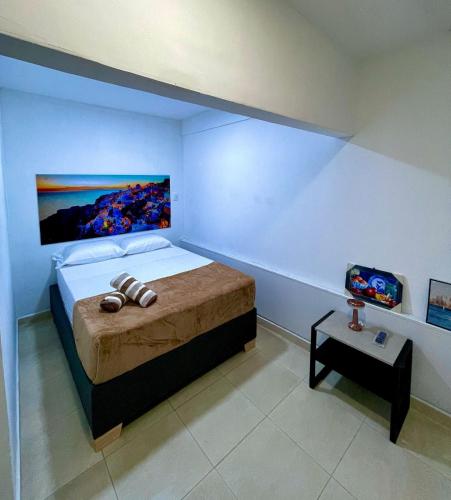 a bedroom with a bed with a painting on the wall at Hospedaje Parque Central src in Santa Rosa de Cabal