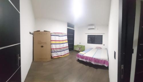 una stanza con un letto e delle scatole dentro di Casa del Zapallo a Portoviejo