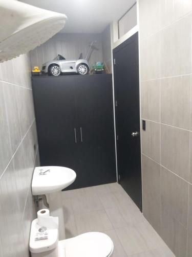 bagno con servizi igienici e una macchina su una mensola di Casa del Zapallo a Portoviejo